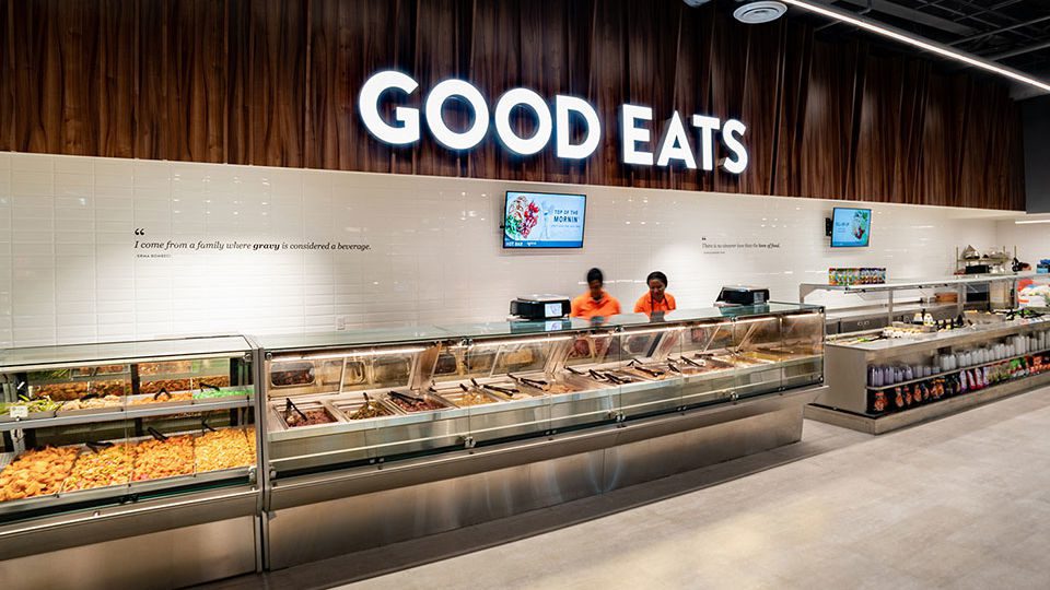 A 64-ft. undulating wooden facade creates a backdrop, highlighting the gourmet prepared foods and salad bar.