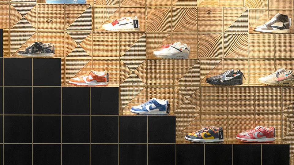 The volumetric matrix, fabricated in ash plywood and 3-D-milled, generates a wavy texture that reveals the layering structure of the wood. The square blocks are framed by brass lines and arranged in such a way as to optimize the visual perception of the products.