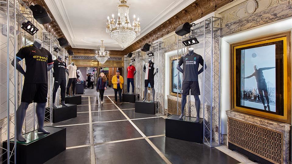 Through stage-craft, the theater’s processional entry hall is transformed into that of a stadium, leading shoppers to the main event, where the landmarked theater plays host to everything soccer.