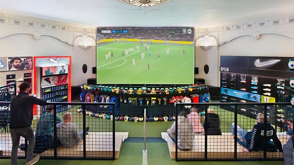 Even the theater’s massive projection screen, once dedicated to running newsreels, has been brought back to life through the latest in display technology, inviting shoppers to relax in the stadium style bleachers and be visually transported to a live action soccer match, at any stadium around the world.