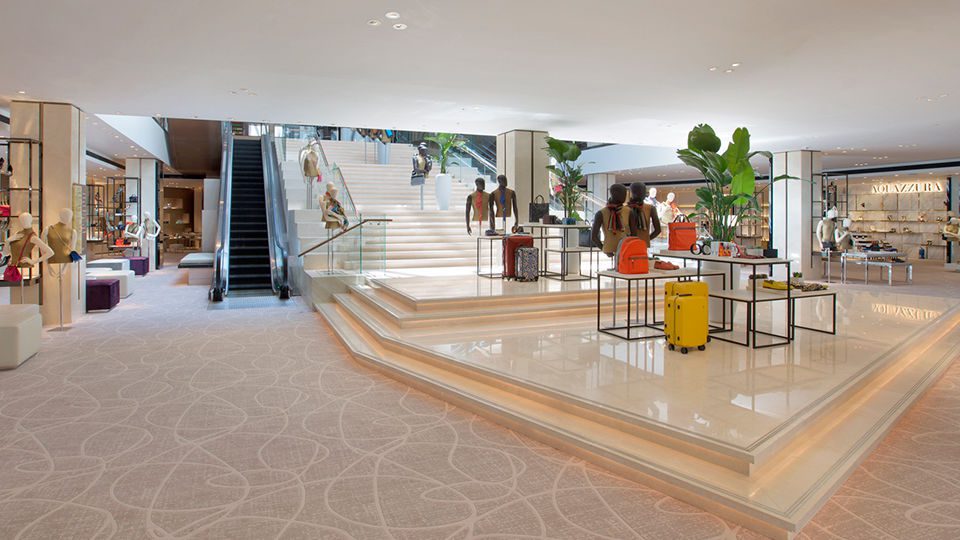 The separated escalators location is featured with a bold multi-level visual merchandising platform leading to a dramatic stair. Landings and numerous levels become opportunities for fashion accessory storytelling amid women’s shoes and designer handbags.
