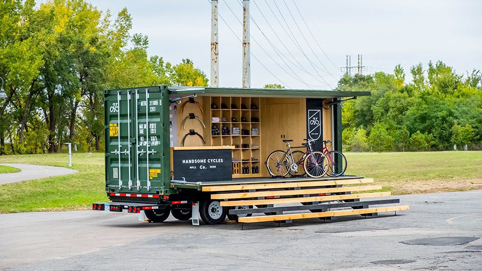 One side of the container fully opens and closes with custom installed hydraulic arms. There are full stairs going up to the container, inviting guests to come inside.