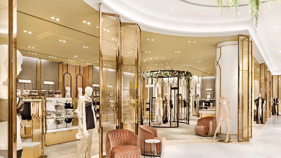 Lingerie is given its own distinct atmosphere, separated from the main floor with layered, rose gold-framed screens, washed-timber fixtures and subtle grey hues.
