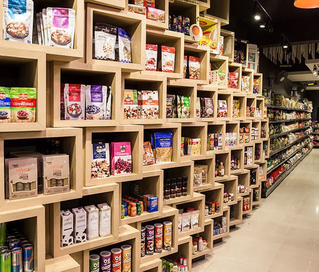 On the main level, new products are stacked in a wall of angular, stacked oak boxes facing towards the customers to form a natural invitation to browse.