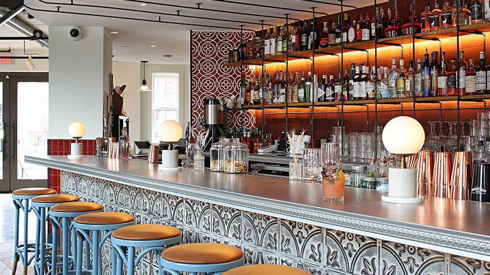 Furthering the “monumental artisans” concept, exposed rebar is used throughout the restaurant and bar areas, working as a double-duty material that is simultaneously practical and ornamental. Climbing the wall into the ceiling to solidify the structure into the building itself, the rebar also appears as the bar footrest and retail shelving.