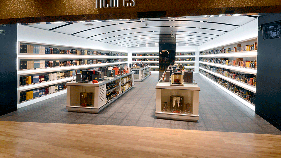 Liquors is a completely different space and shopping experience than the wine area. Dark floor tile with retro illuminated walls and niches that present the merchandise are covered by a vaulted metal ceiling.