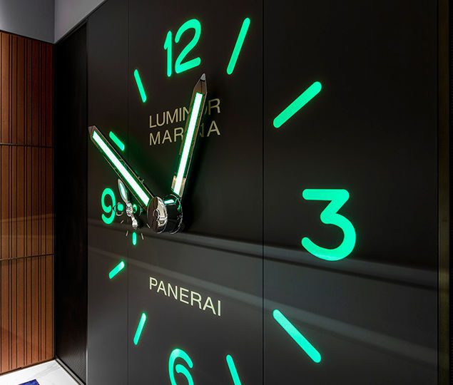 On the back wall, a striking clock face creates a focal point, with the surrounding merchandise display cases branching off for browsing.