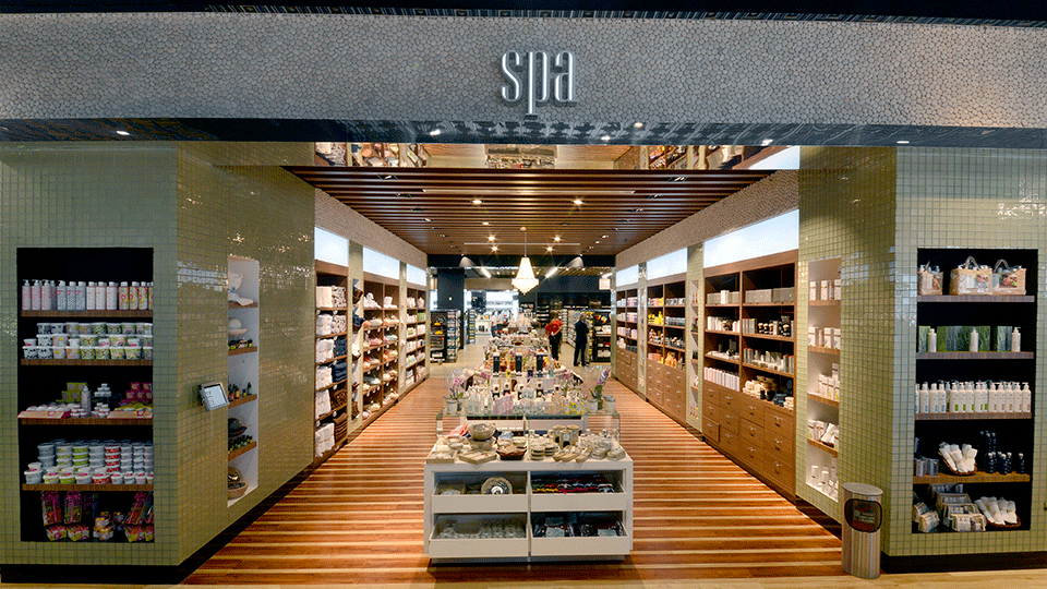 In the Spa area, a combination of light and dark wood floors give the area a nautical feeling. The perimeter is made of wood as well with a green mosaic and coral tile at the top. A central chandelier anchors the whole area.