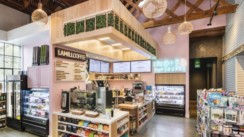 Through the entrance, the open-concept market comes into full view —refrigerators and metal dry storage racks house health-conscious food options.