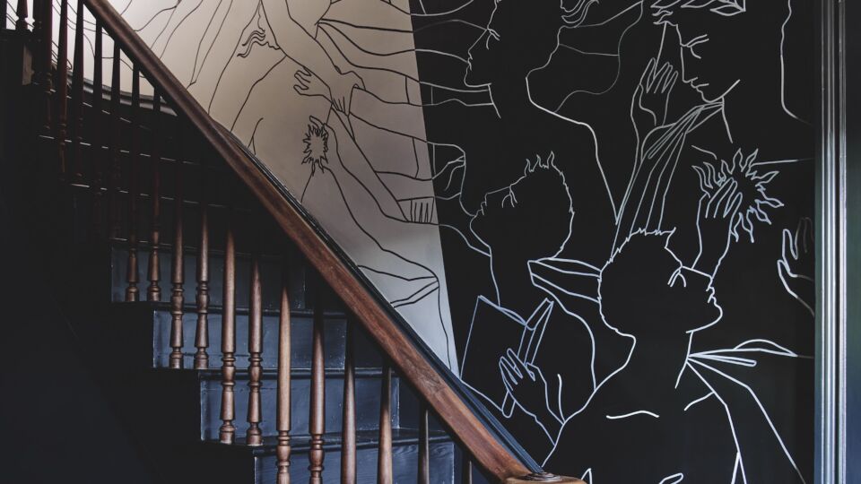 A freehand wall mural by Italian artist Roberto Ruspoli lines the stairway.