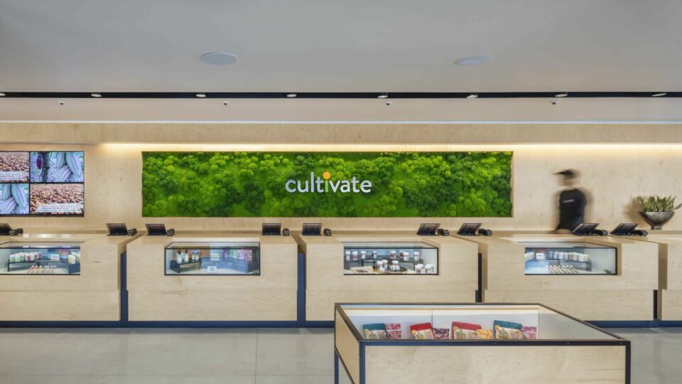 The client services area features natural materials used for the custom wood counters. A preserved moss wall alcove enhances the branded logo.