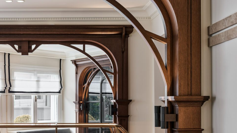 The arches clearly “zone” different spaces within the showroom. Marquetry flooring with a striking geometric design is used throughout the space, with jewelry showcased in glass display cabinets, anchored by a wooden base with drawers creating accessible storage.