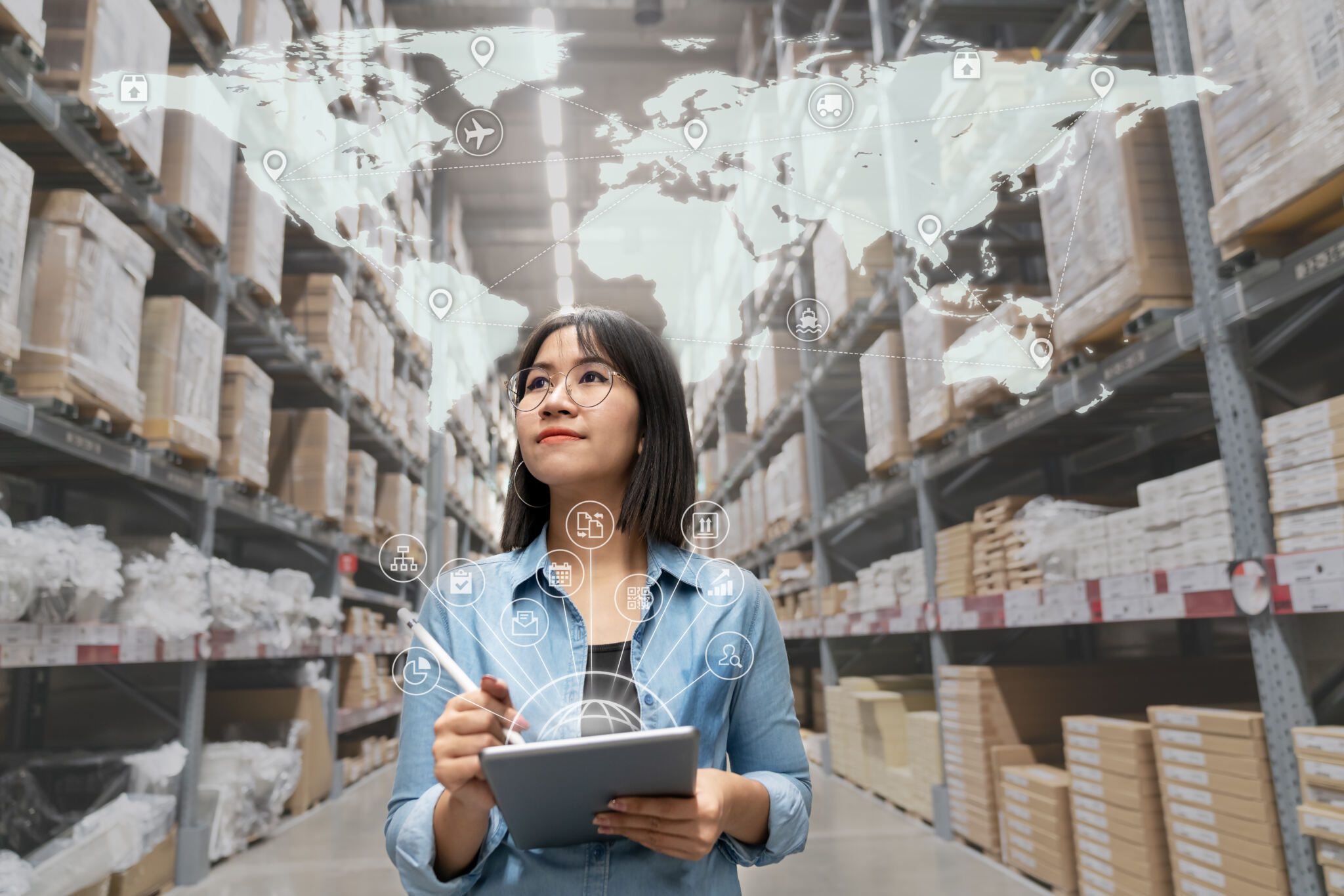 Woman walking through a warehouse taking inventory using a tablet