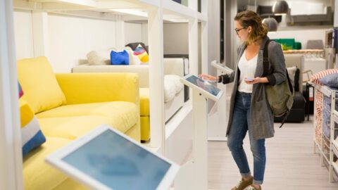 A woman interacting with a digital display in a furniture store