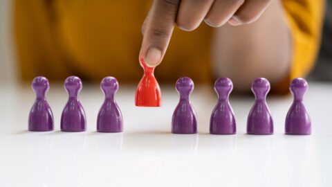 Person picking up a red game piece