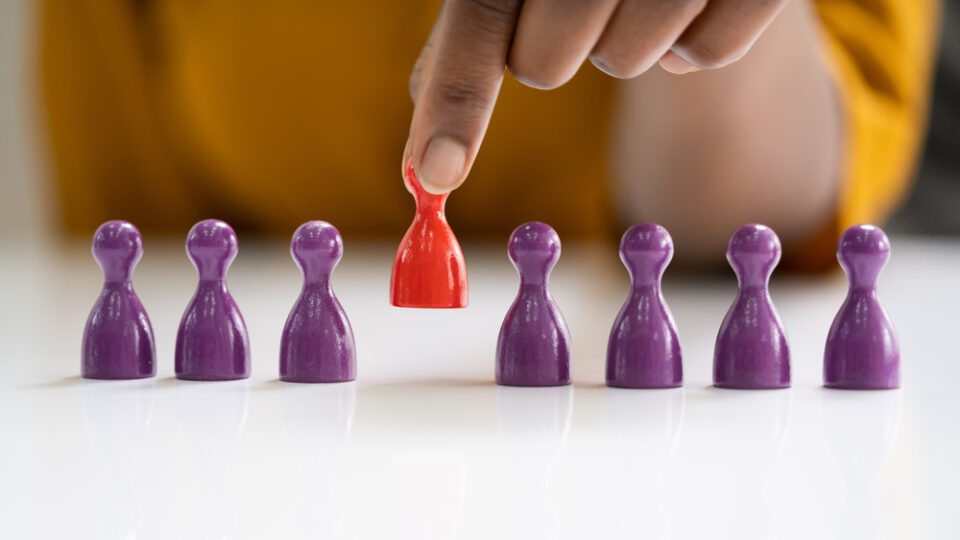 Person picking up a red game piece