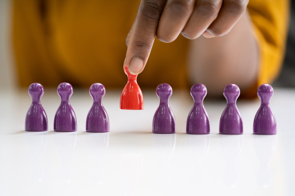 Person picking up a red game piece