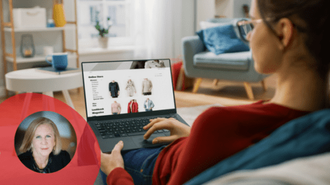 Young woman in glasses and red sweater, browsing a retailer site on a laptop. The laptop screen shows rows of products.