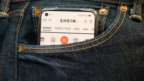 An image of a smartphone with the SHEIN ecommerce site on it. The smartphone is in a pocket for a pair of jeans.