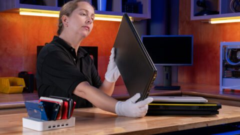 A Newegg employee inspects a laptop for resale.