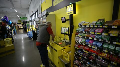 A man uses the self-checkout at Dollar General.