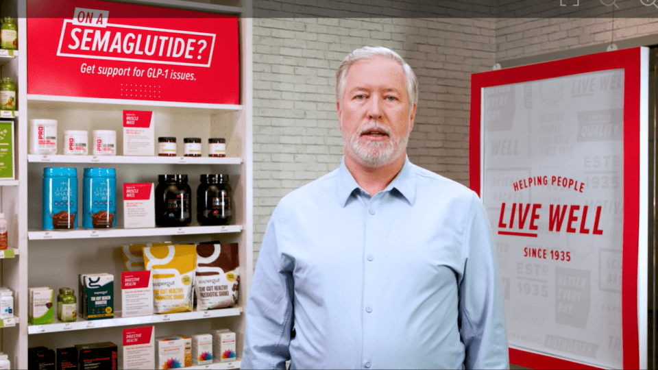 GNC CEO Michael Costello in front of the retailer's new GLP-1 section.